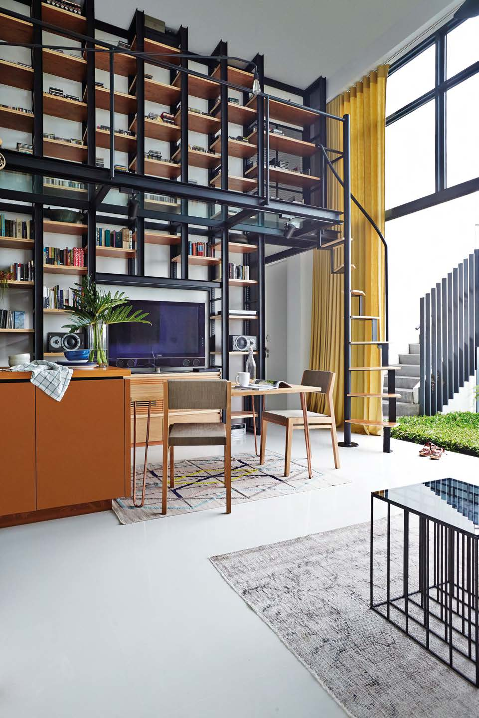 The steel-andplywood bookshelf is the design focal point of the apartment.