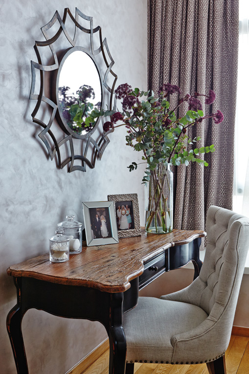 The vintage-style dresser adds a romantic touch to the bedroom and provides an elegant display space for photographs and accessories.